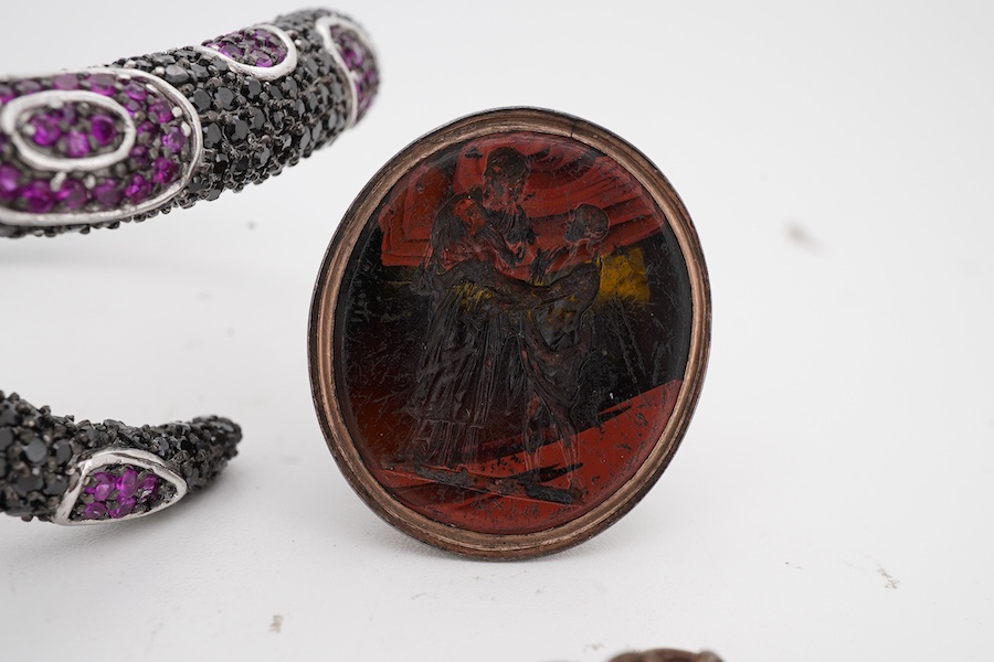 A collection of jewels including a snake bracelet, comprising: a hinged bangle modelled as a snake in silver, pavé-set with circular-cut black sapphires and synthetic rubies, its tongue a marquise-shaped synthetic ruby,